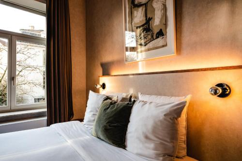 a bedroom with a bed with white sheets and pillows at Monsieur Maurice in Bruges