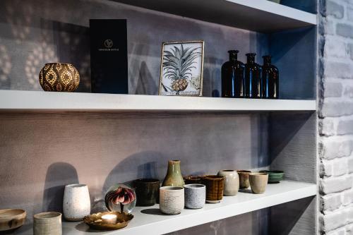 a shelf with bottles and vases on it at Monsieur Maurice in Bruges