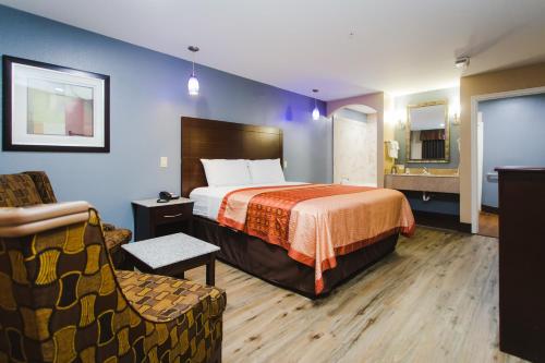 a hotel room with a bed and a chair at Home Place Inn in Houston