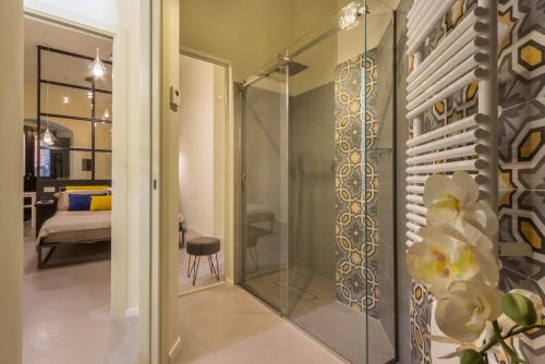 a glass shower door in a room with a bedroom at Suite Cagliari -97- in Cagliari