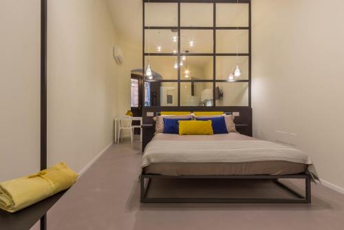 a bedroom with a large bed with yellow pillows at Suite Cagliari -97- in Cagliari