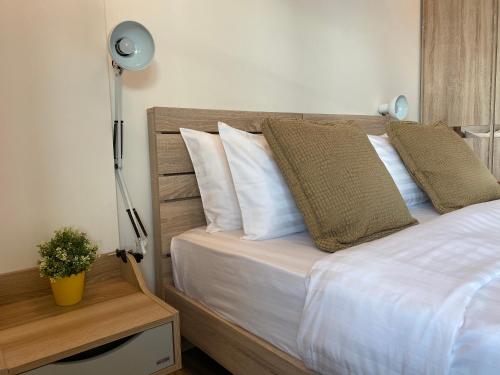 um quarto com uma cama com lençóis brancos e almofadas em Summer Condo Hua Hin Room710 em Hua Hin