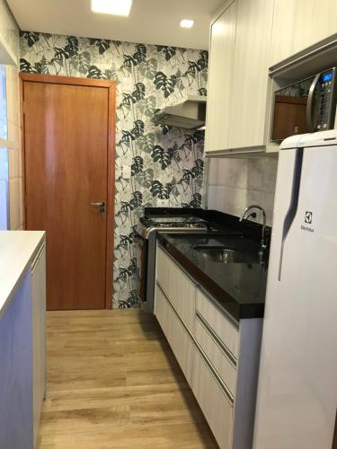 a kitchen with a sink and a refrigerator at Liberdade 1 QT + Sofá Cama - 200m Metrô. Novo! in Sao Paulo