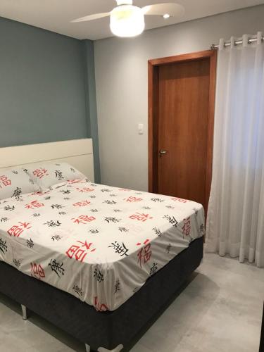 um quarto com uma cama com um edredão branco em Liberdade 1 QT + Sofá Cama - 200m Metrô. Novo! em São Paulo