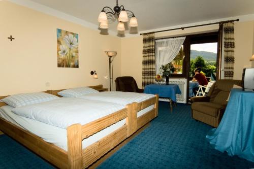 Un dormitorio con una cama y una sala de estar. en Landhotel Rappenhof, en Arnbruck