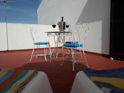 una mesa y sillas con una botella de vino. en Familia Brito, en Porches