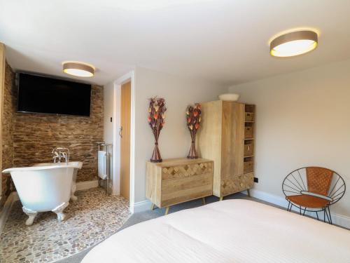 een slaapkamer met een bed, een bad en een wastafel bij Rosebank Cottage in Woolacombe