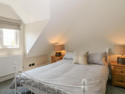 een slaapkamer met een wit bed en een raam bij Rosebank Cottage in Woolacombe