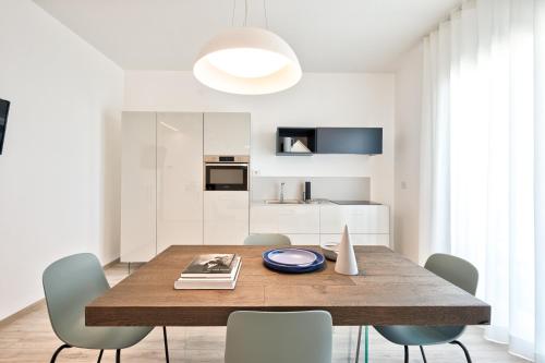 a dining room with a wooden table and chairs at Albamarina Residence in Sottomarina