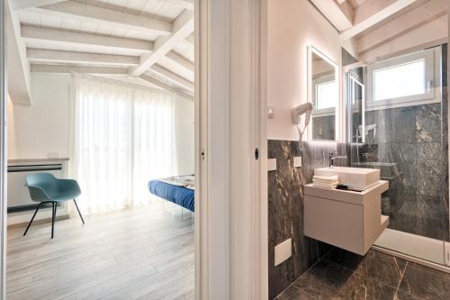 ein Bad mit einem Waschbecken und ein Bett in einem Zimmer in der Unterkunft Albamarina Residence in Sottomarina