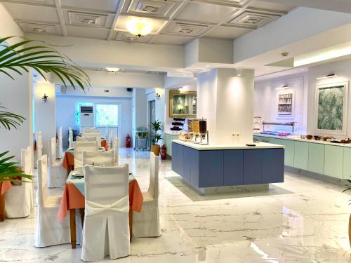 a restaurant with tables and chairs in a room at Paloma Blanca in Dassia