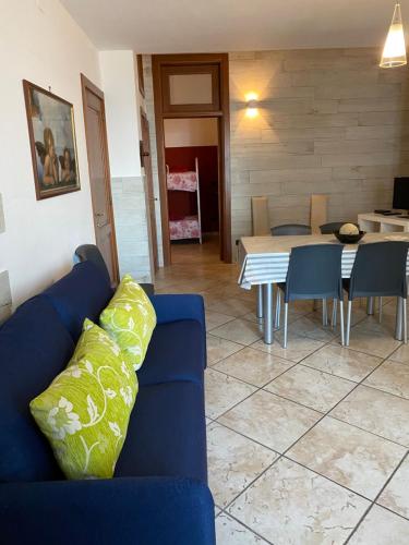 een woonkamer met een blauwe bank en een tafel bij Appartamento in Via Tricarico in Gallipoli