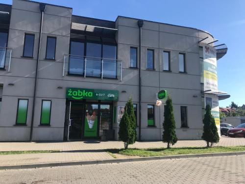 a grey building with a green door on a street at Apartament Lemon in Pruszcz Gdański