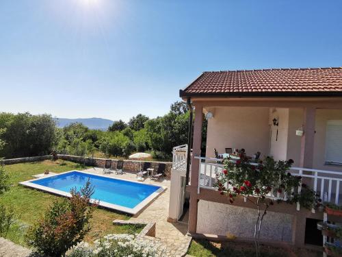 a villa with a swimming pool next to a house at Apartman Selma in Vinine