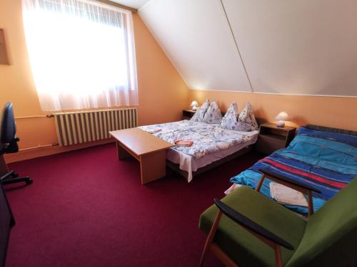 a bedroom with a bed and a table and a window at Erika Apartman Klímával in Balatonkeresztúr