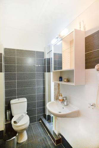 a bathroom with a toilet and a sink at Vento di Mare in Perea
