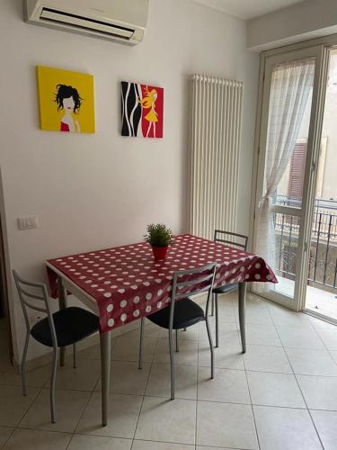 mesa de comedor con sillas y mantel rojo y blanco en Vacanze a Cupra Marittima en Cupra Marittima