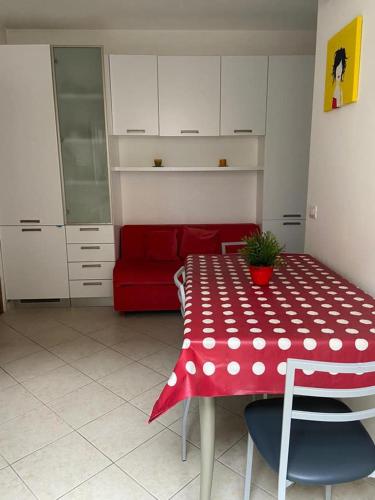 a kitchen with a red and white table and a red couch at Vacanze a Cupra Marittima in Cupra Marittima