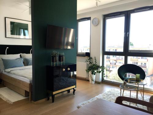 een slaapkamer met een bed en een tv aan de muur bij Green Apartment Gdańsk z GARAŻEM in Gdańsk