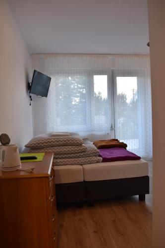 a bedroom with a bed with a window and a desk at Villa Danusia in Ustronie Morskie