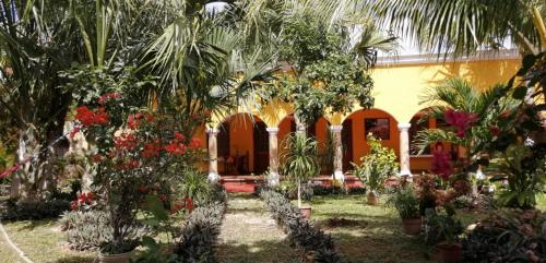 a house with trees and flowers in the yard at Casa Palagui Colonial in Valladolid