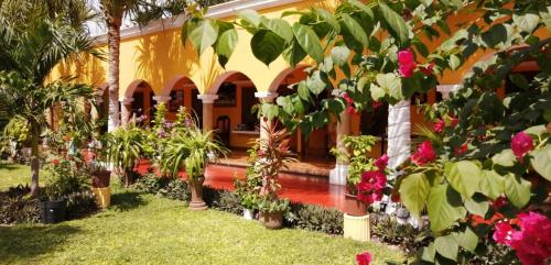 a garden in front of a house with flowers at Casa Palagui Colonial in Valladolid