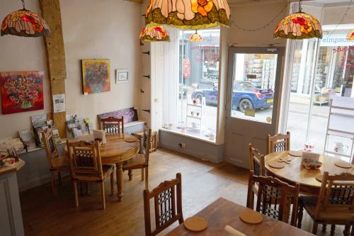 a dining room with tables and chairs and a car outside at The Poppy House in Bishops Castle