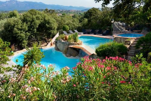 a swimming pool with blue water in a garden at Résidence Storia di Blue in Porto-Vecchio