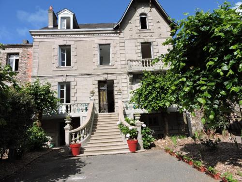 een groot wit huis met een trap ervoor bij Lime trees in Arnac-Pompadour