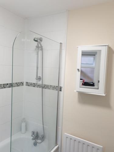 uma casa de banho com um chuveiro, um lavatório e um espelho. em Chatham Private Rooms em Chatham