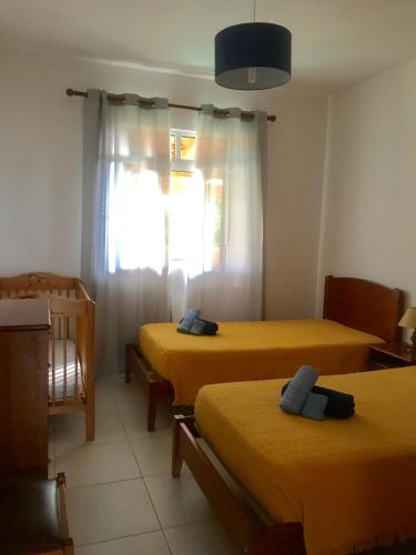 a room with two beds and a window at Cantinho Solpraia in Porto Santo
