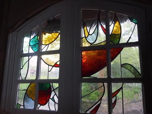 a window with a bunch of stained glass at Grote Goesting holiday house in Wevelgem