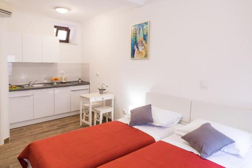 Duas camas num pequeno quarto com uma cozinha em Apartments Santa Maria em Dubrovnik