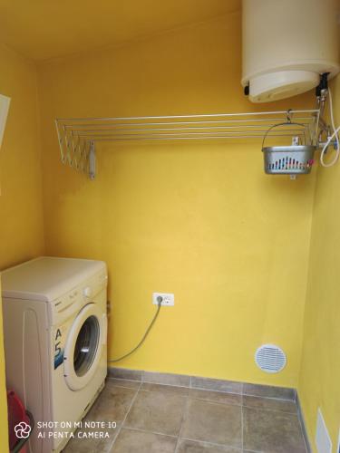 eine Waschmaschine und einen Trockner in einem Zimmer mit gelber Wand in der Unterkunft La casita de Candida in Tigaday