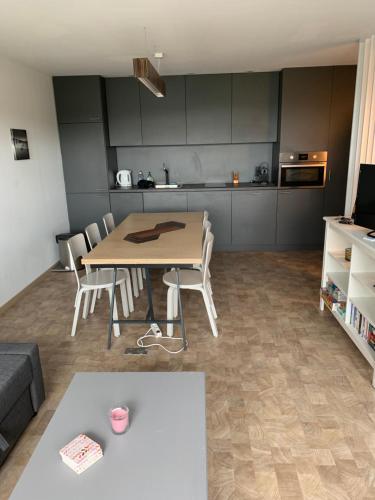 a living room with a table and chairs and a kitchen at TERRASSES DE MALMEDY Triplex 259 " C EST LA VIE " in Malmedy