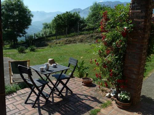 einen Tisch und Stühle auf einer Backsteinterrasse in der Unterkunft Casa Rural La Cortina in Pandiello