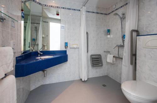 uma casa de banho com um lavatório azul e um WC. em Holiday Inn Express Taunton East, an IHG Hotel em Taunton