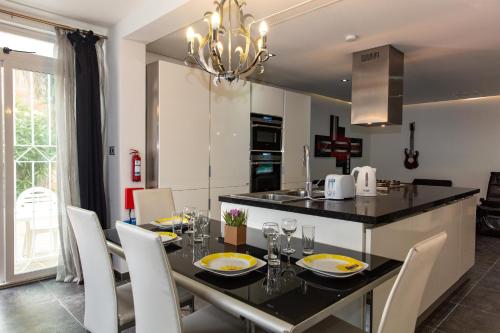 a kitchen and dining room with a table and chairs at Dolmen Court Flat 10, Qawra in St. Paul's Bay