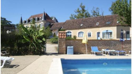 une maison avec une piscine devant une maison dans l'établissement Corail, à Queyssac