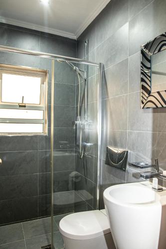 a bathroom with a toilet and a glass shower at Dolmen Court Flat 10, Qawra in St. Paul's Bay