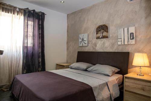 a bedroom with a bed and a window at Dolmen Court Flat 10, Qawra in St. Paul's Bay