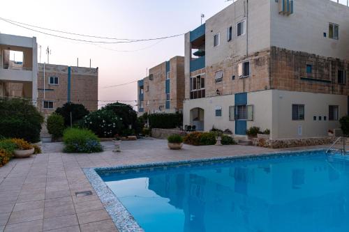 a swimming pool in front of a building at Dolmen Court Flat 10, Qawra in St. Paul's Bay