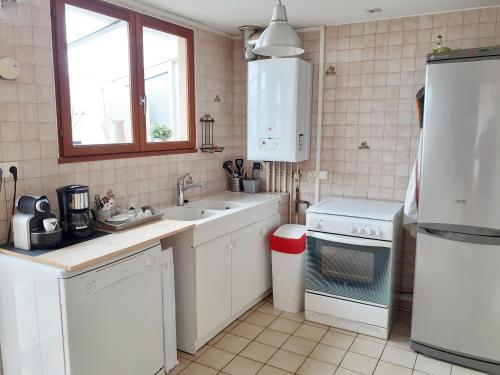 a white kitchen with a sink and a stove at AMBROGIO in Amboise