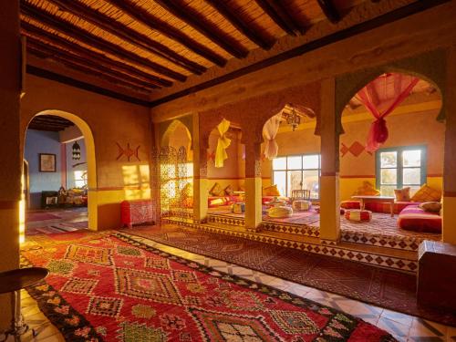 a large living room with a rug on the floor at Kasbah Erg Chebbi in Merzouga