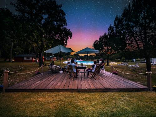 a group of people sitting around a table on a wooden deck at Chalet do Lago in Montargil