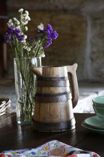 a table with a vase of flowers and a tea pot at CASA da PISCINA, Quinta do Espinho, Douro Valley in Tabuaço