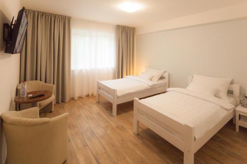 a room with two beds and a table and a chair at Golf Čertovo břemeno in Jistebnice