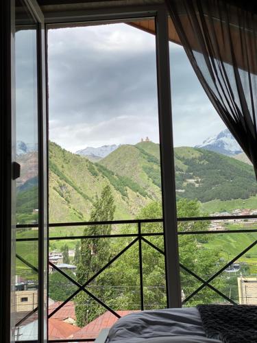 a bedroom with a window with a view of mountains at Uptown Boutique Kazbegi in Kazbegi