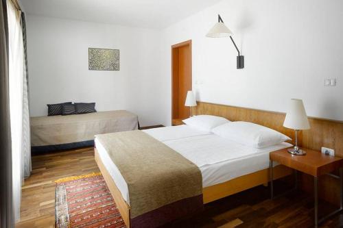 a bedroom with two beds and a table with a lamp at Private luxury Villa AZZURRO on Solta for up to 10 persons, free parking, very close to beach! FREE Kajak & Mountainbikes, GREAT living area & privacy! in Rogač