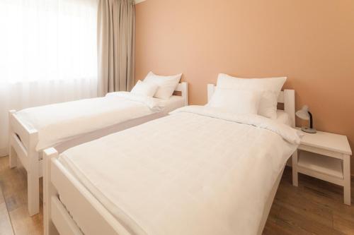 two white beds in a room with a window at Golf Čertovo břemeno in Jistebnice